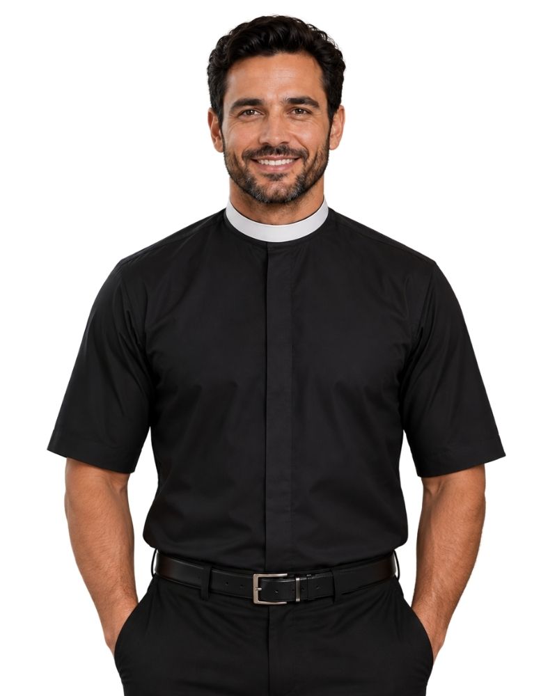 A smiling man wearing a black short-sleeve clerical shirt with a white collar, paired with black trousers and a black belt, against a plain white background.