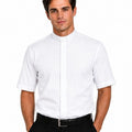 A man wearing a white short-sleeve clerical shirt with a high mock neck collar, paired with black trousers and a black belt, against a plain white background.