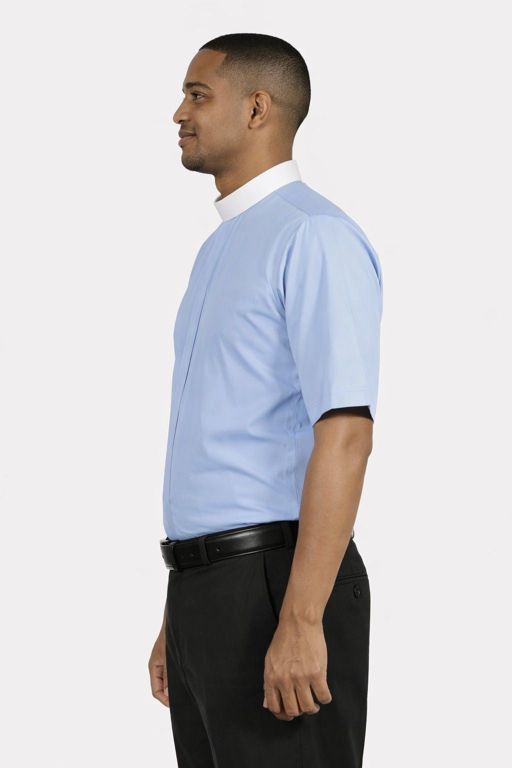 Man wearing a light blue shirt with black pants on a white background