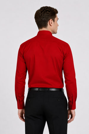 Man wearing a red shirt and black pants on a white background