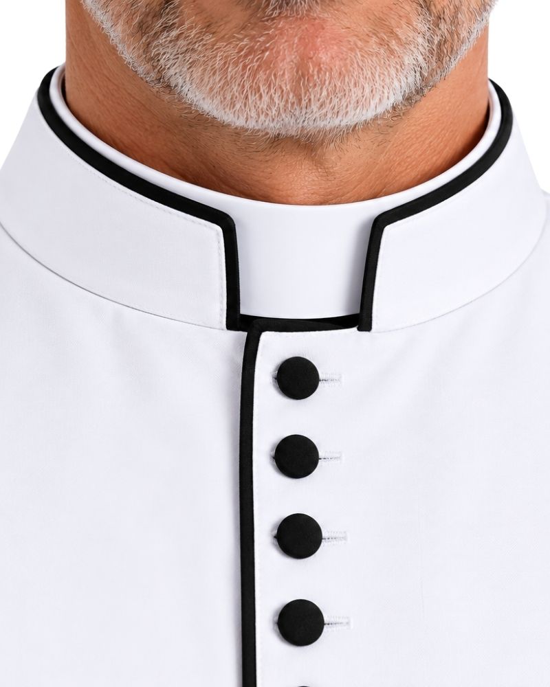 Close-up of a Cohen White And Black Cassock with black piping trim and black buttons, worn by a man.