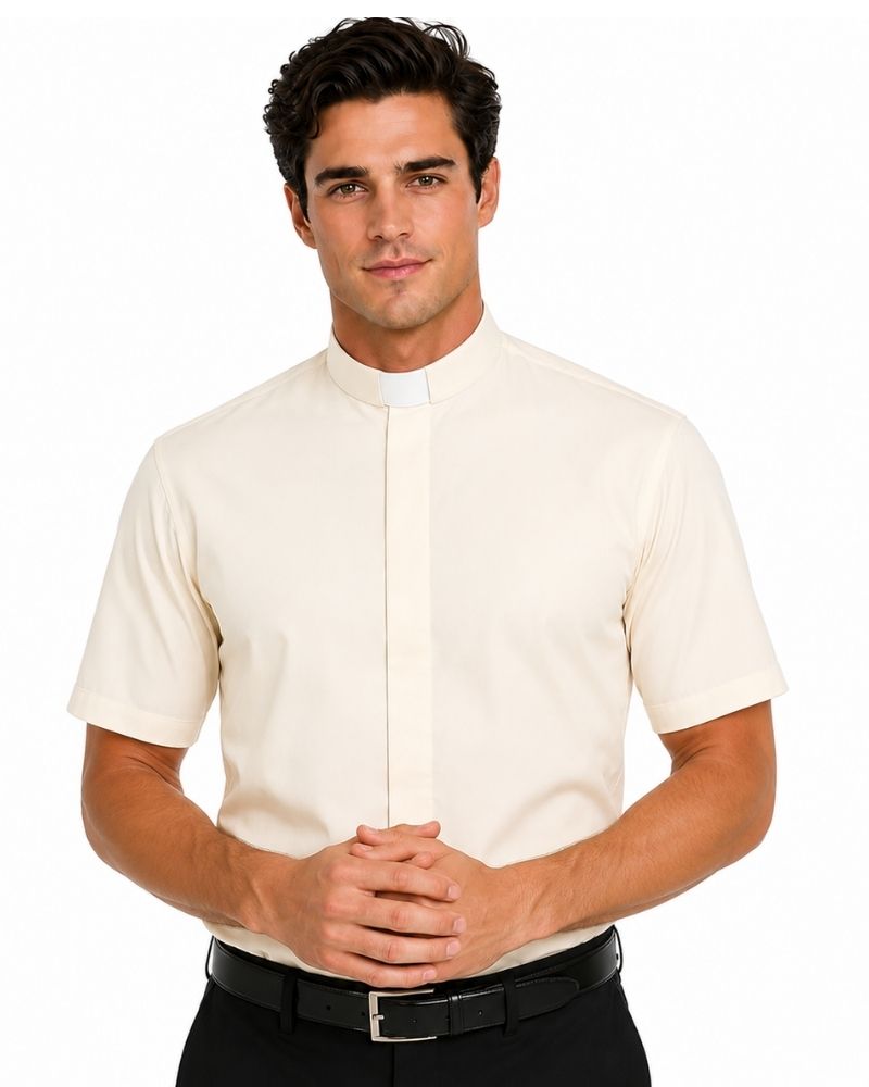 A man wearing a cream-colored short-sleeve clerical shirt with a white collar, paired with black trousers and a black belt, against a plain white background.
