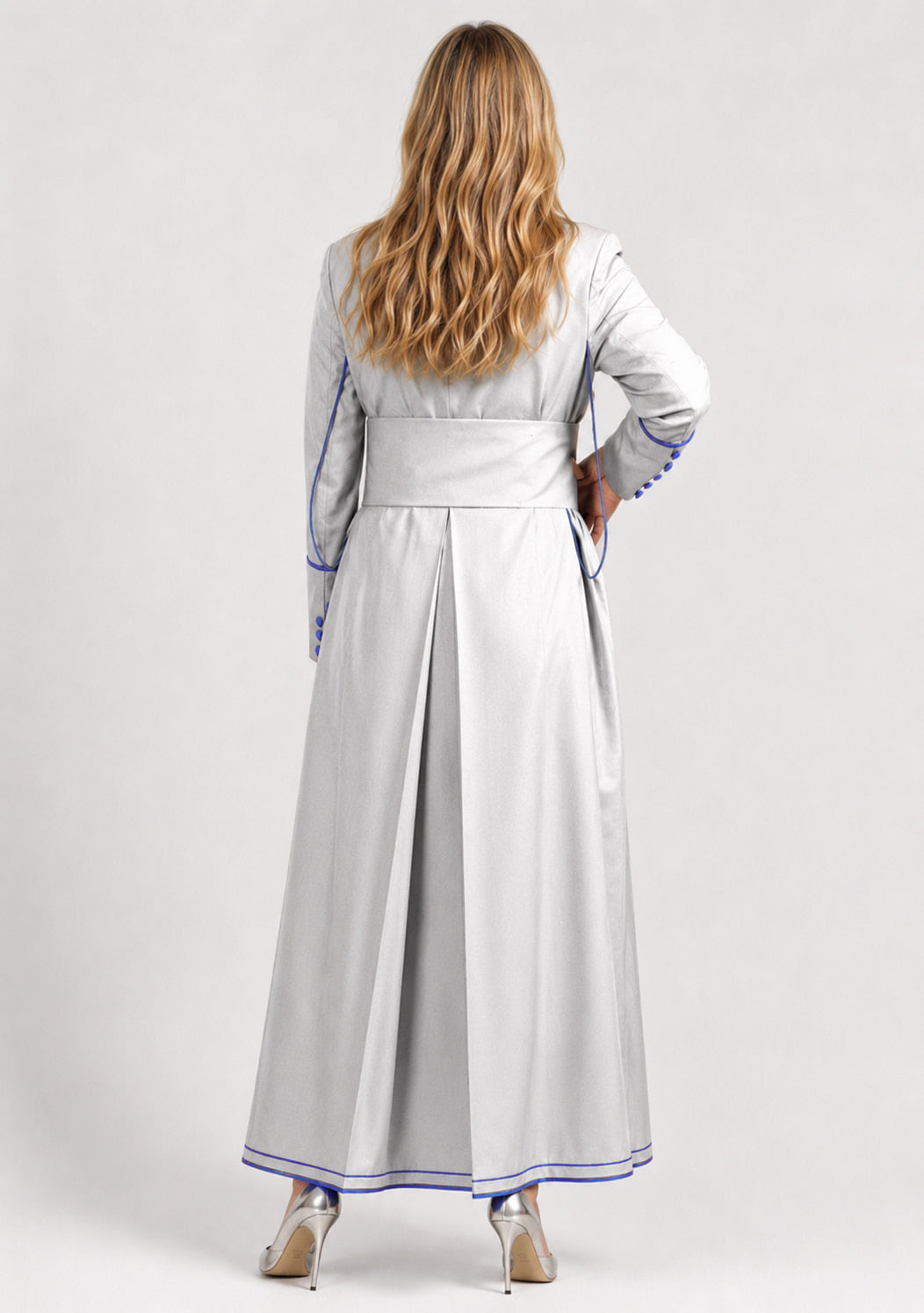Woman wearing a long light gray robe with blue trim on a white background