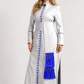 Woman wearing a long white robe with blue accents on a white background