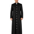 A man modeling a long black clerical cassock with a high collar, white collar insert, and a front button closure, photographed against a plain white background.