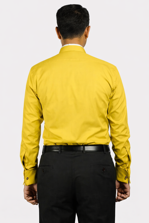Man wearing a yellow shirt and black pants on a white background