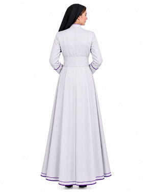 A woman shown from the back wearing a White Clergy Cassock With Purple Trim with purple piping trim on the collar, cuffs, and hem, against a plain white studio background.