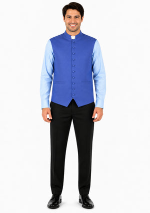 Man wearing a blue vest over a light blue shirt with black pants on a white background