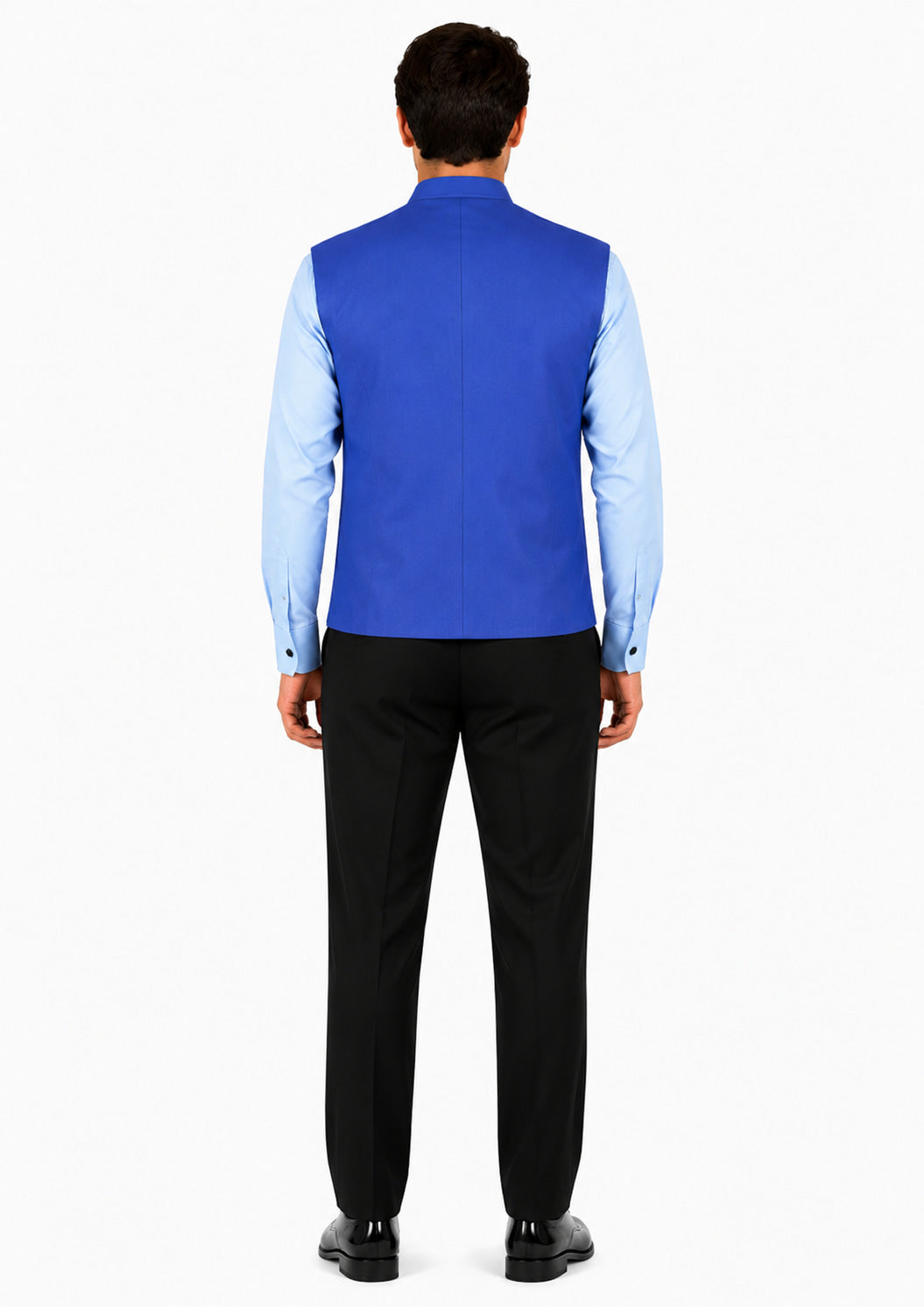 Man wearing a blue vest over a light blue shirt with black pants on a white background