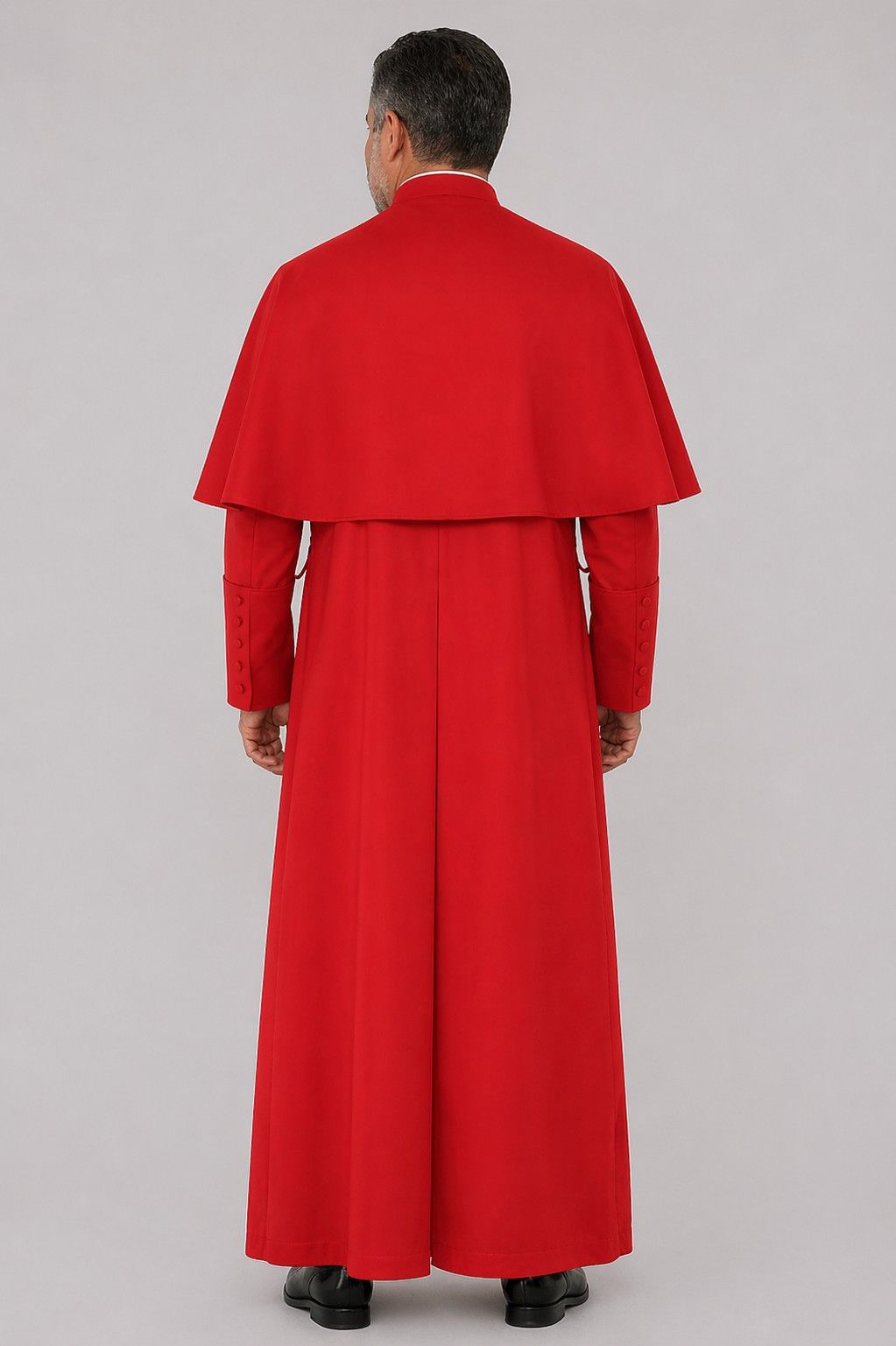 Person wearing a red robe and cape on a gray background