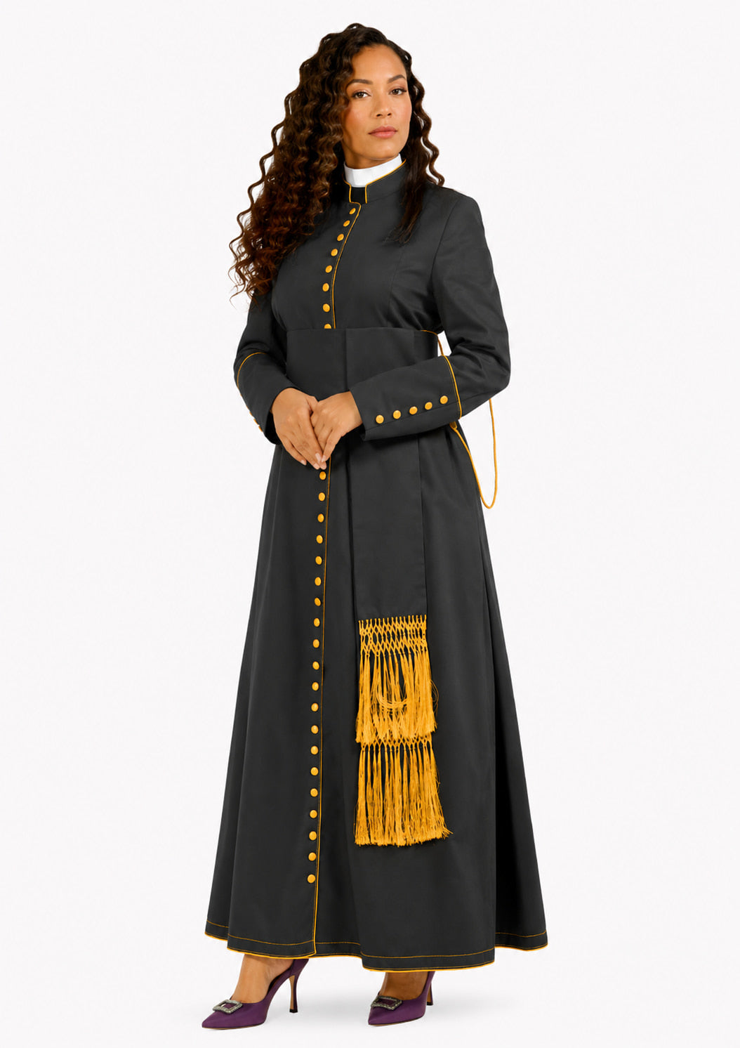 Woman wearing a black robe with yellow buttons and fringes on a white background