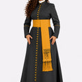 Woman wearing a black robe with yellow accents and a matching scarf on a white background