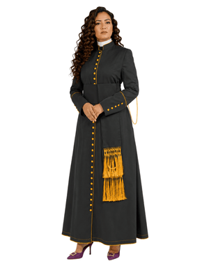 A woman modeling a long dark gray traditional cassock with gold button details, gold fringe trim, and a white collar, set against a plain white background.