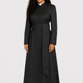 Woman wearing a black long cassock with a white collar on a white background
