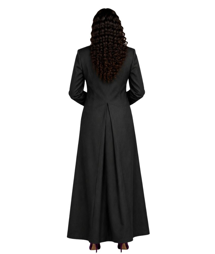 A woman viewed from the back wearing a long black cassock with long sleeves and a gathered waist seam, shown against a plain white background.