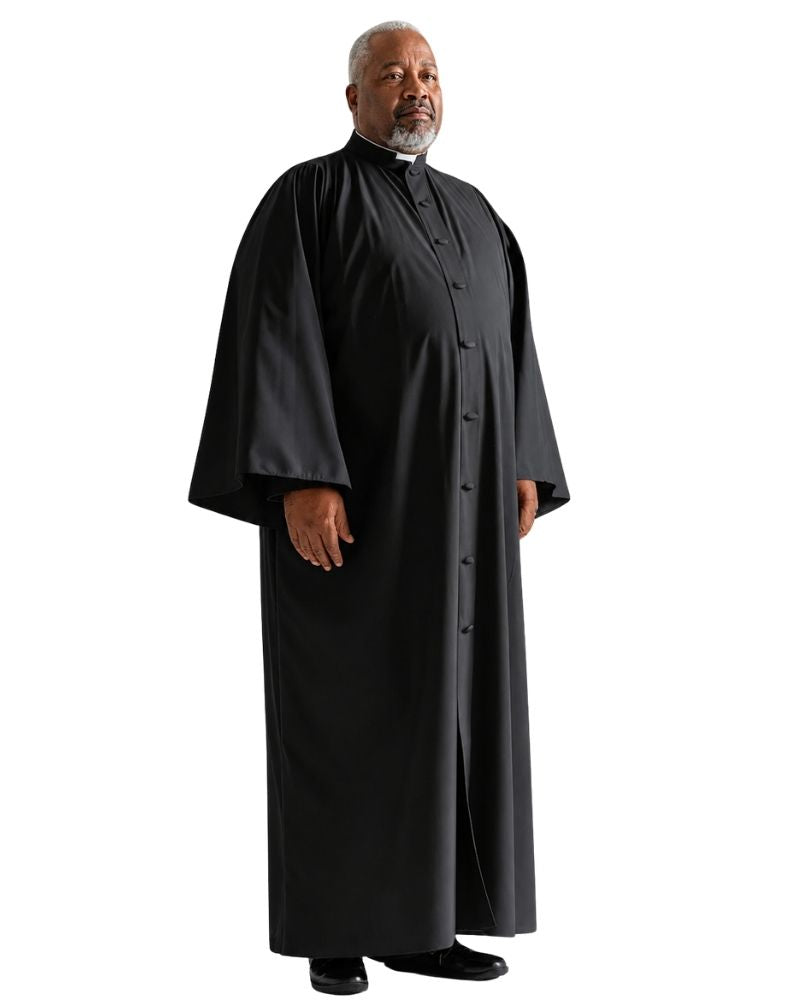 A man modeling a long black clerical robe with a high collar, standing against a plain white background.