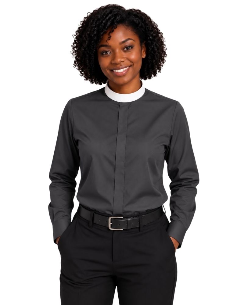 A smiling woman with curly black hair wearing a dark charcoal gray long-sleeve clerical shirt with a contrasting white crew neck collar, paired with black trousers and a black belt, against a plain white background.