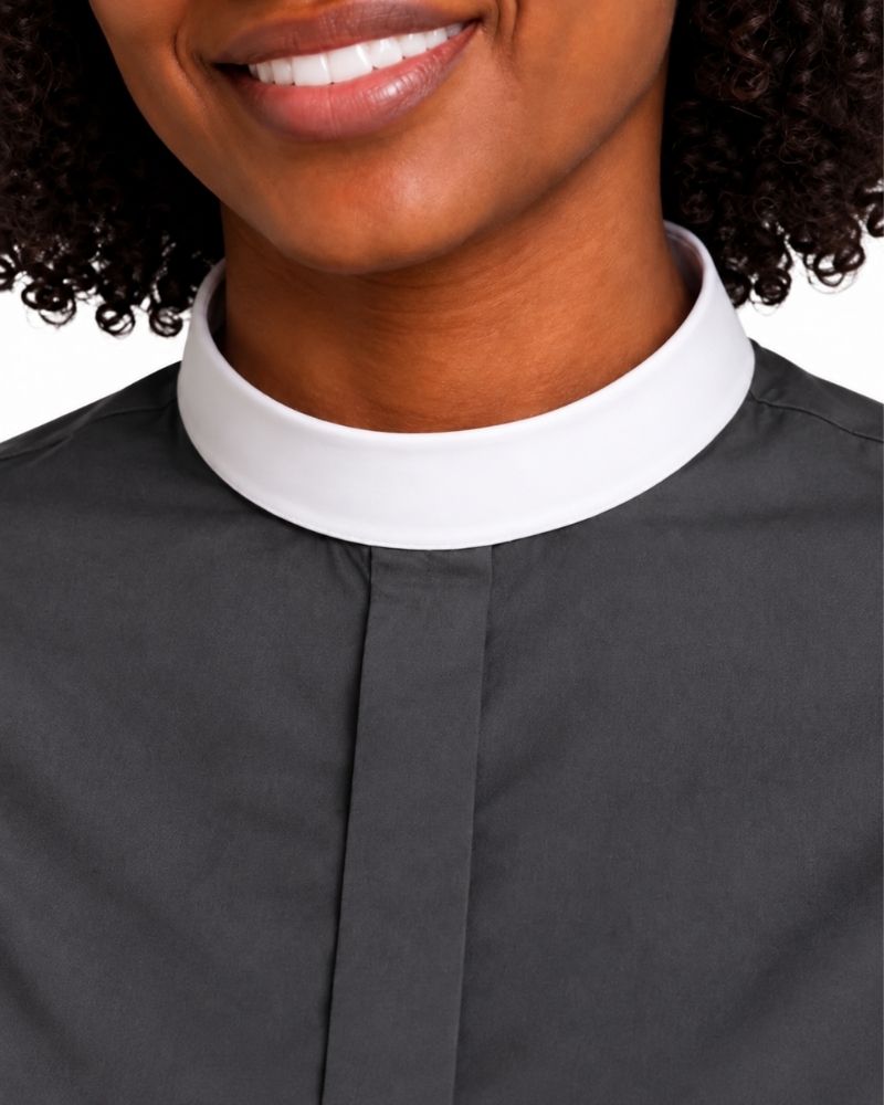 Close-up of a woman wearing a dark charcoal gray clerical shirt with a contrasting white collar.