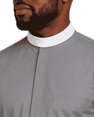 Close-up of a man wearing a light gray clerical shirt with a white clerical collar, cropped from the lower face to the chest against a plain white background.
