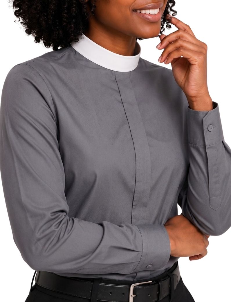 A woman wearing a long-sleeve gray clerical shirt with a white collar, paired with a black belt, shown against a plain white background.