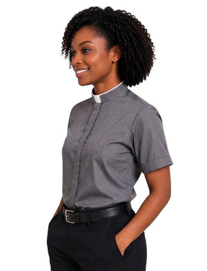 A woman wearing a short-sleeve gray clerical shirt with a white collar, paired with black trousers and a black belt, shown against a plain white background.