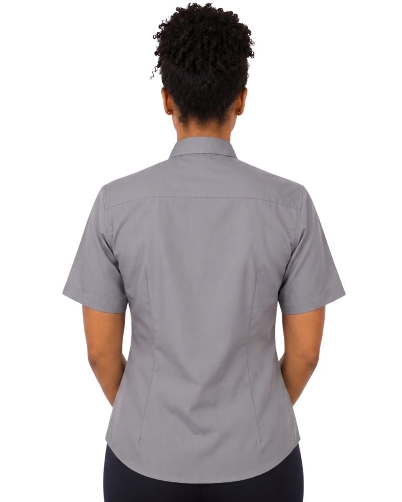 A woman viewed from the back wearing a short-sleeve gray clerical shirt and dark pants, against a plain white background.