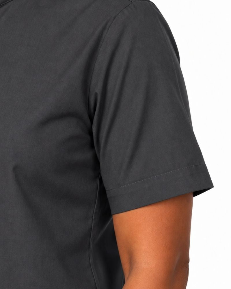 Close-up of a woman wearing a dark charcoal gray short-sleeve clerical shirt, showing the sleeve cuff and side seam against a plain white background.