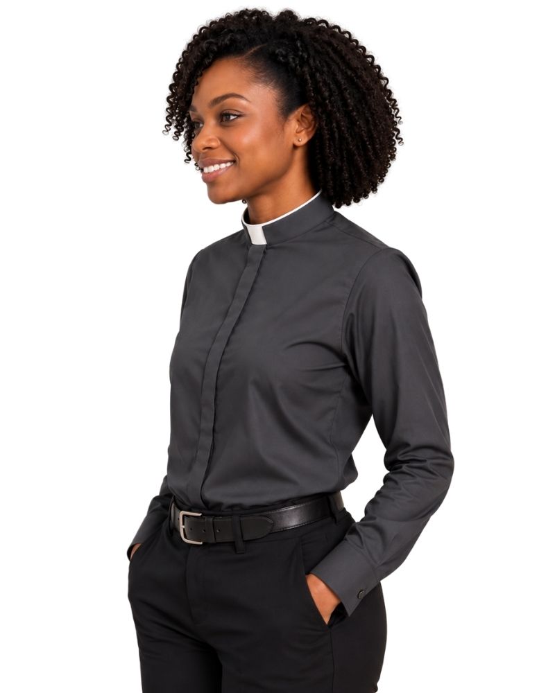 A woman wearing a dark gray long-sleeve clerical shirt with a white collar, paired with black trousers and a black belt, shown from a side profile against a white background.