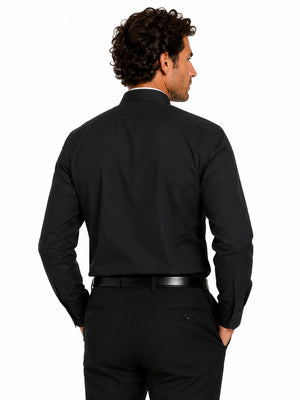 Man wearing a black clerical shirt and pants on a white background