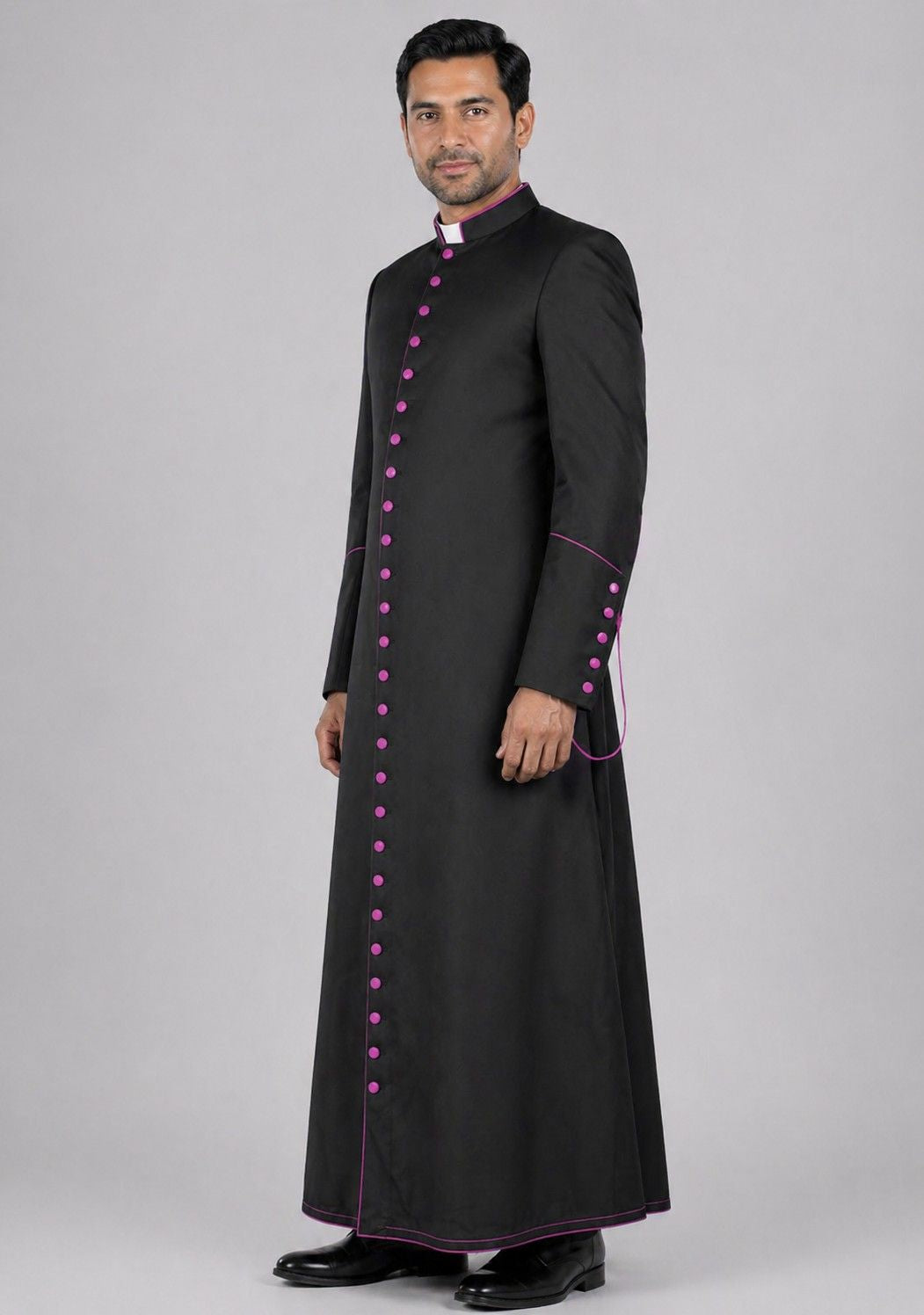 Man wearing a black robe with pink buttons on a gray background