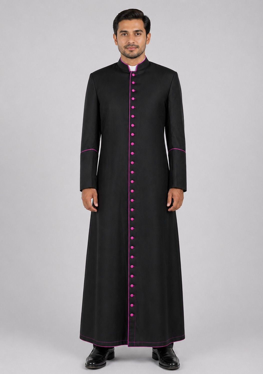 Man wearing a black robe with pink accents on a gray background