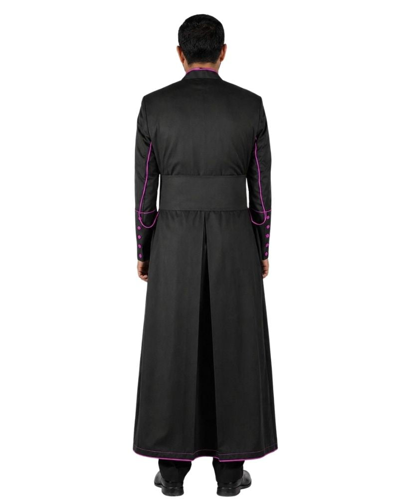 A man viewed from the back wearing a long black Cassock  with bright pink trim along the collar, cuffs, and hem, against a plain white background.