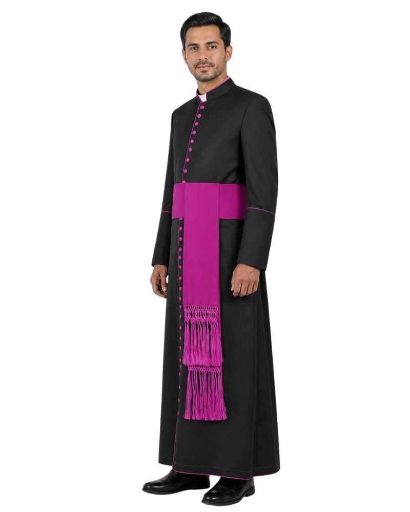 A man modeling a black priestly cassock with a bright magenta-purple sash and matching buttons, set against a plain white background.