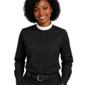 A woman shown from the front wearing a black long-sleeve clerical shirt with a white collar, paired with black trousers and a black belt, against a plain white background.