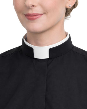 A close-up of a woman wearing a black clerical shirt with a white collar, set against a plain white background.