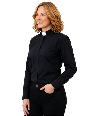 A woman with wavy light brown hair wearing a black long-sleeve clerical shirt with a white collar, paired with black pants, shown against a plain white background.