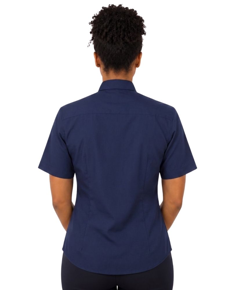 A woman viewed from the back wearing a navy blue short-sleeve clerical shirt and dark pants, set against a plain white background.