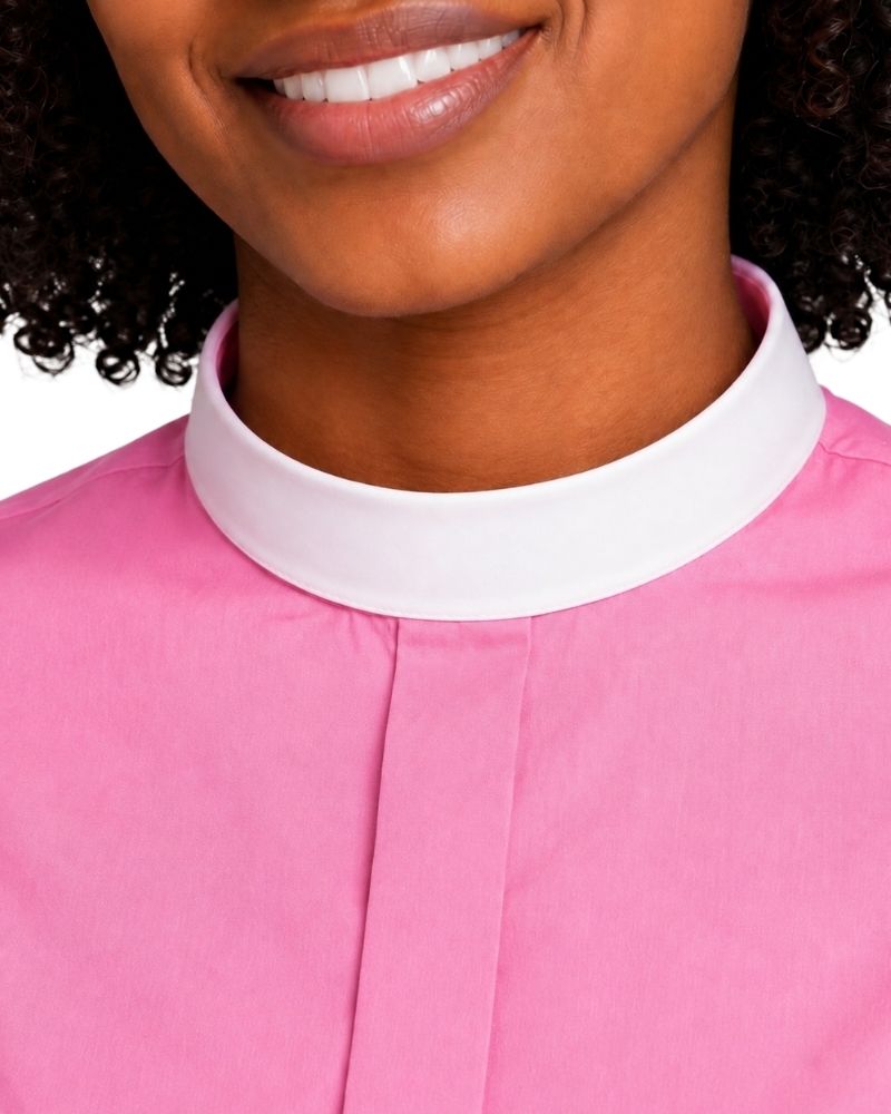 Close-up of a woman wearing a pink top with a contrasting white high collar, cropped from the mouth to the chest against a plain white background.