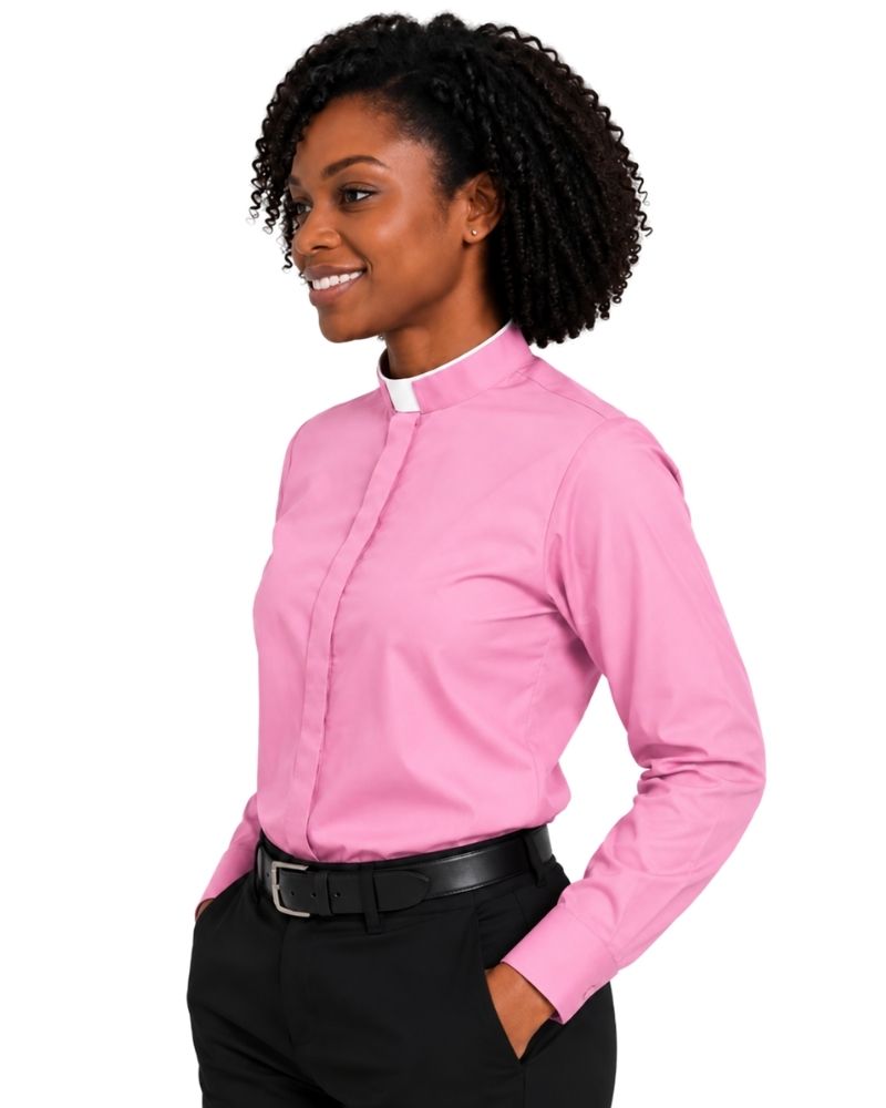 A woman wearing a pink long-sleeve clerical shirt with a white collar, paired with black trousers and a black belt, shown against a plain white background.