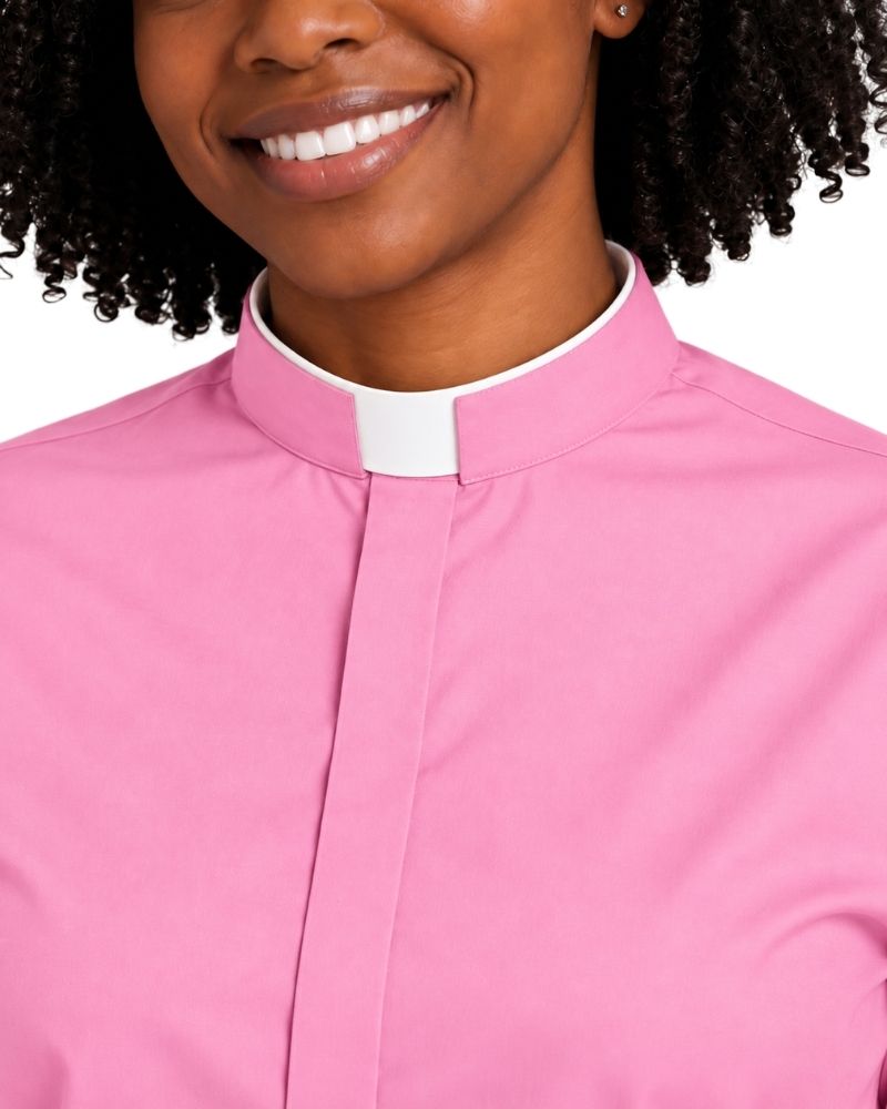 Close-up of a pink short-sleeve clerical shirt on a model, showing the neck collar, against a plain white background.