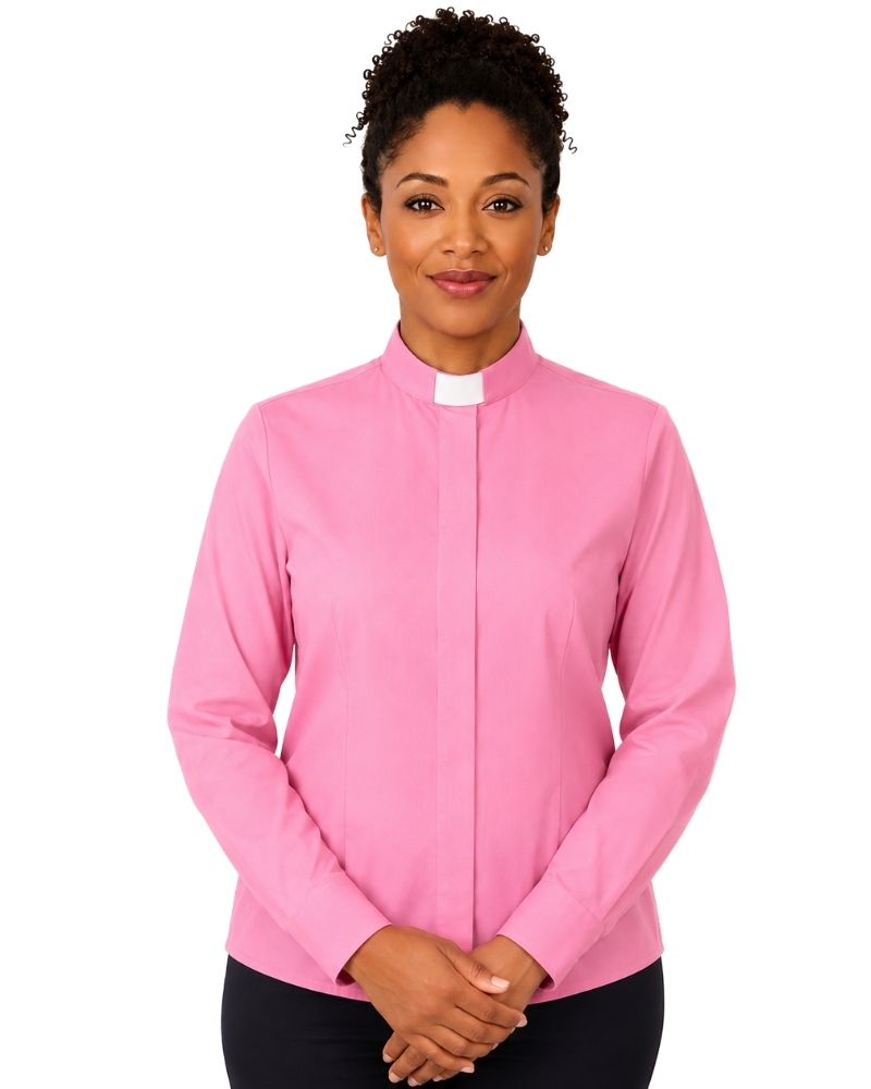 A woman wearing a pink long-sleeve clerical shirt with a white collar, standing against a plain white background.