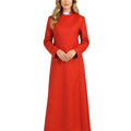 A woman modeling a long-sleeved, high-neck cassock with black cuffs, paired with red high heels, against a plain white background.