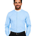 A smiling man wearing a light blue long-sleeve clerical shirt with a unique center-front split design, paired with black trousers and a black belt, against a solid white background.