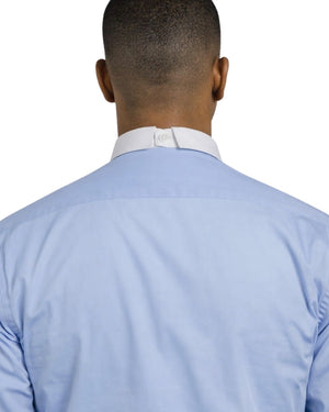 Man wearing a light blue shirt with a white collar and black pants on a white background
