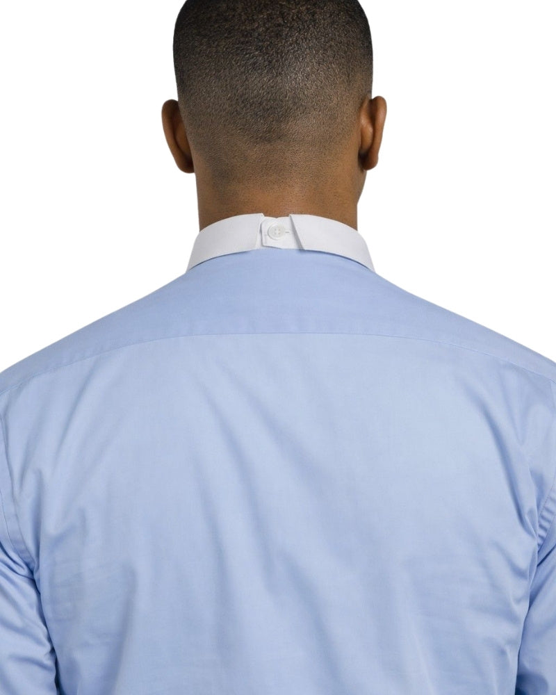 Man wearing a light blue shirt with a white collar and black pants on a white background