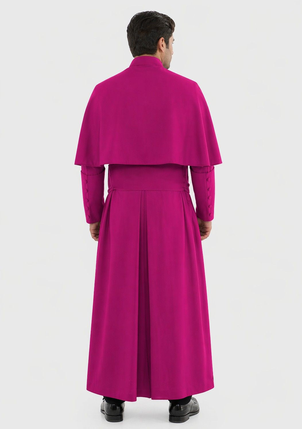 Man wearing a bright pink outfit with a long robe on a white background