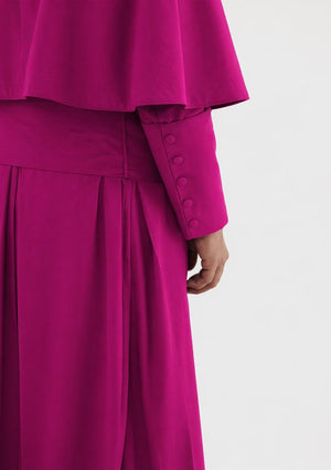 Close-up of a bright pink outfit with buttons on a white background