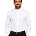A smiling man wearing a white long-sleeve clerical shirt with a high mock neck and a central pleat detail, paired with black trousers and a black belt, against a plain white background.