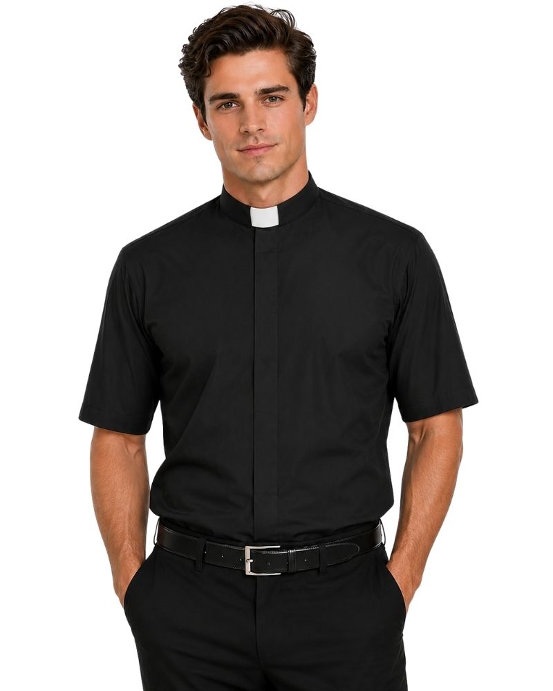 A man wearing a black short-sleeve clerical shirt with a white collar tab, paired with black trousers and a black belt, against a plain white background.