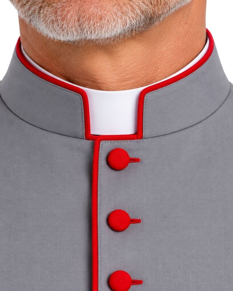Close-up of a Gray Cassock With Red Trim with red piping trim and red buttons, worn by a person with a white collar visible underneath.